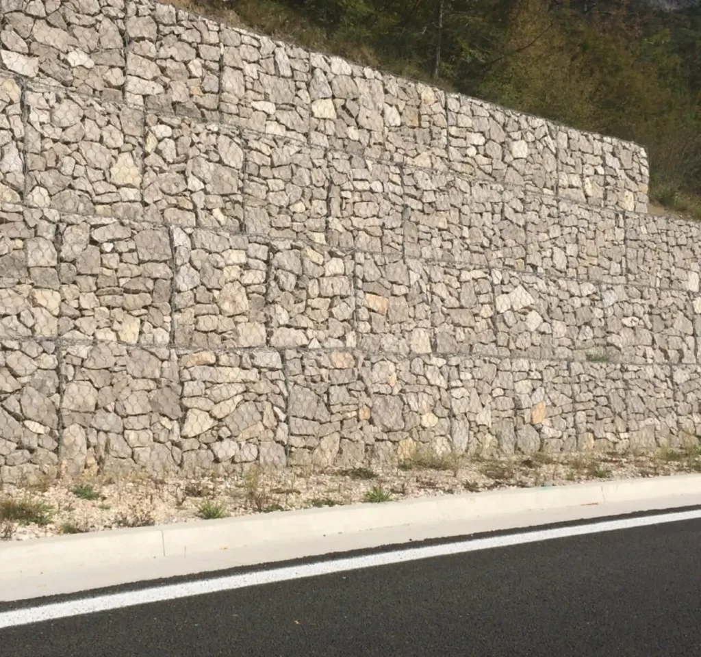 Gabion Retaining Walls by Retaining Walls Tauranga, constructed with stacked stone-filled mesh cages to stabilize a roadside slope.